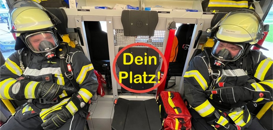 Auf dem foto sind zwei Personen mit Outfit der Feuerwehr zu sehen, die in einem Feuerwehrauto sitzen und auf einen leeren Platz in der Mitte zeigen. Auf dem leeren Platz steht mittig Dein Platz in gelber Schrift, um die Wörder ist ein roter Kreis.