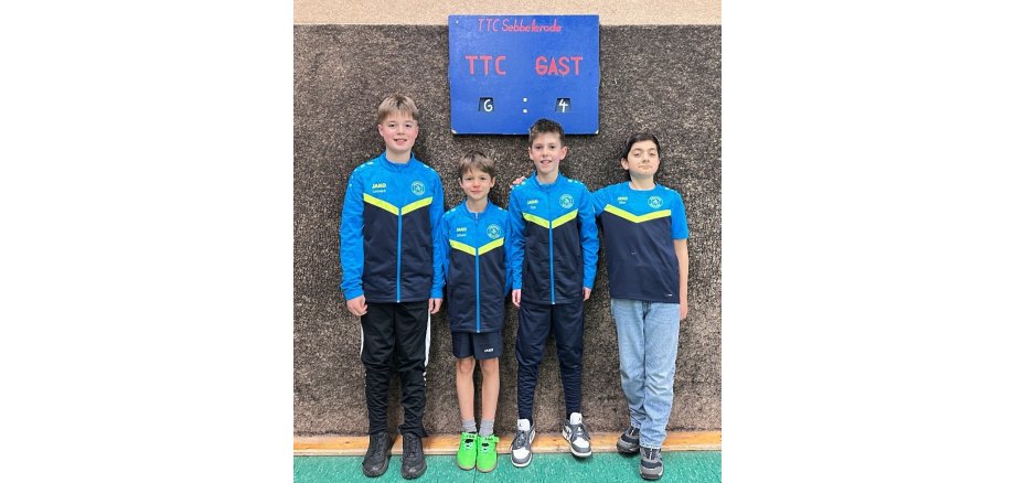 Auf dem Bild sind vier Kinder zu sehen, die vor einer Tafel stehen, die die Punkteanzahl des Spiels des TTC Sebbeterode Winterscheid anzeigt; TTC 6 Punkte und Gast 4 Punkte.