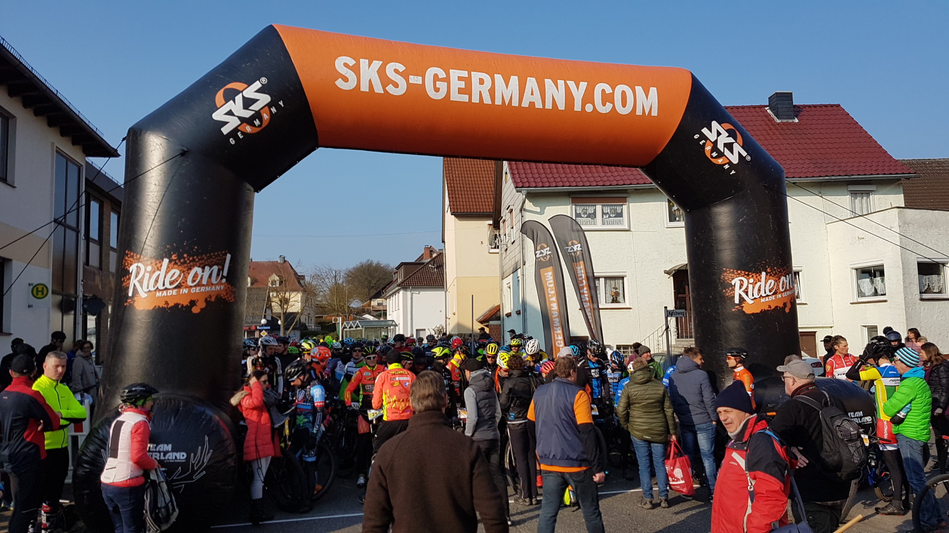 Es ist ein Bild des Startes bei einem der vergangen Bikemarathon zu sehen, auf dem Personen vor dem Start stehen.