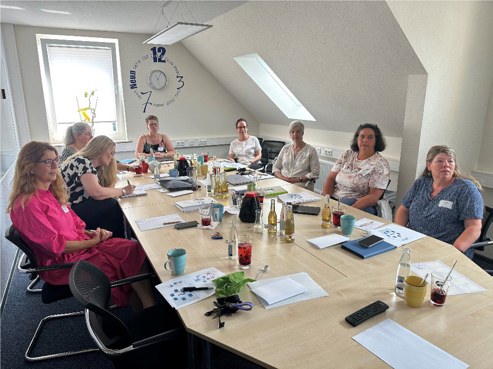 Teilnehmende des Workshop 2024 an einem Tisch sitzend