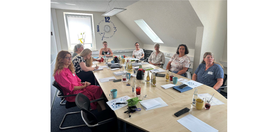 Teilnehmende des Workshop 2024 an einem Tisch sitzend