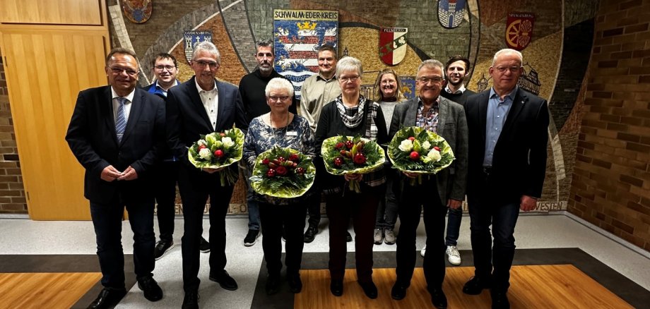 Bild vorne von links: Landrat Winfried Becker, die Verabschiedeten Thomas Horn, Monika Götting, Heike Gerlach und Holger Raude, Erster Kreisbeigeordneter Jürgen Kaufmann. Hinten von links: Florian Geißer – Vorsitzender des Personalrates, Gerhard Reuter – nachfolgender Fachbereichsleiter Bauen und Umwelt, Lars Werner – Fachbereichsleiter Sozialamt, Ninette Bender – Mitarbeiterin des Fachbereichs Liegenschaften und Reinigungsservice und Tobias Heipel – Personalleiter.