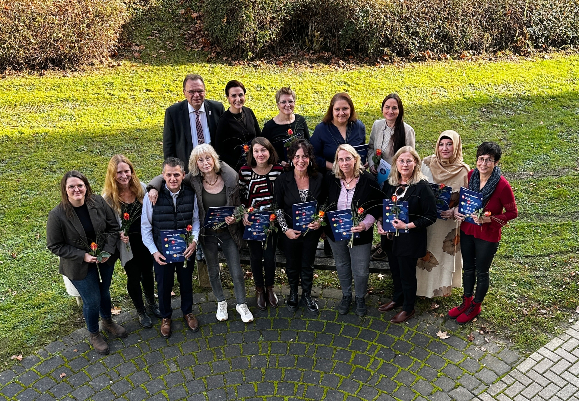 Auf dem Foto sind Personen zu sehen, die eine Rose in der Hand halten.