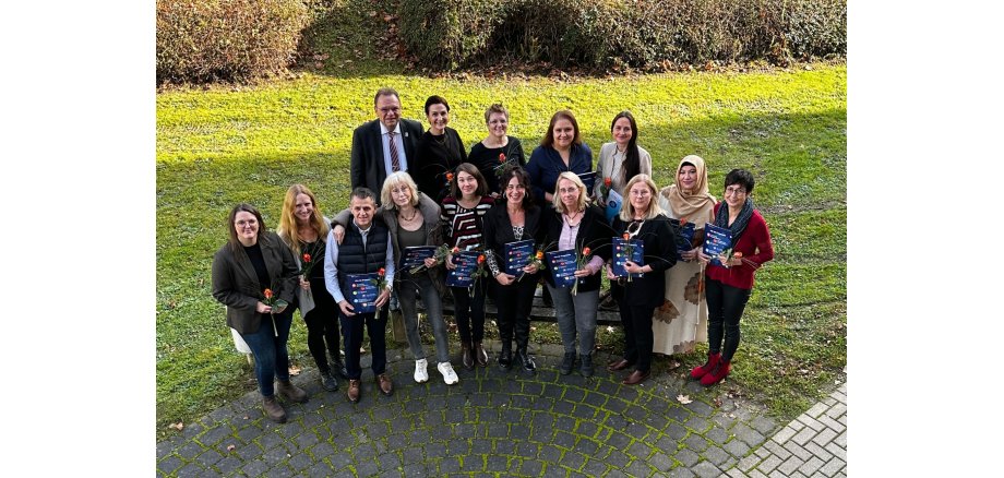 Auf dem Foto sind Personen zu sehen, die eine Rose in der Hand halten.