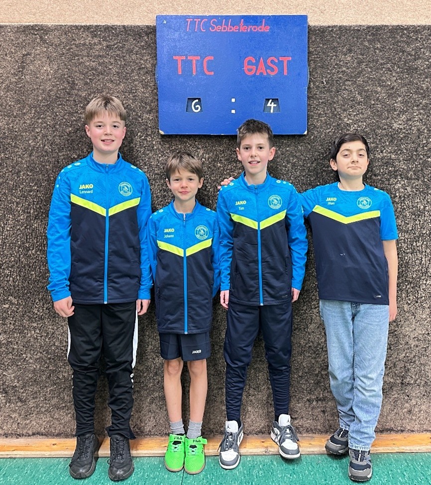 Auf dem Bild sind vier Kinder zu sehen, die vor einer Tafel stehen, die die Punkteanzahl des Spiels des TTC Sebbeterode Winterscheid anzeigt; TTC 6 Punkte und Gast 4 Punkte.