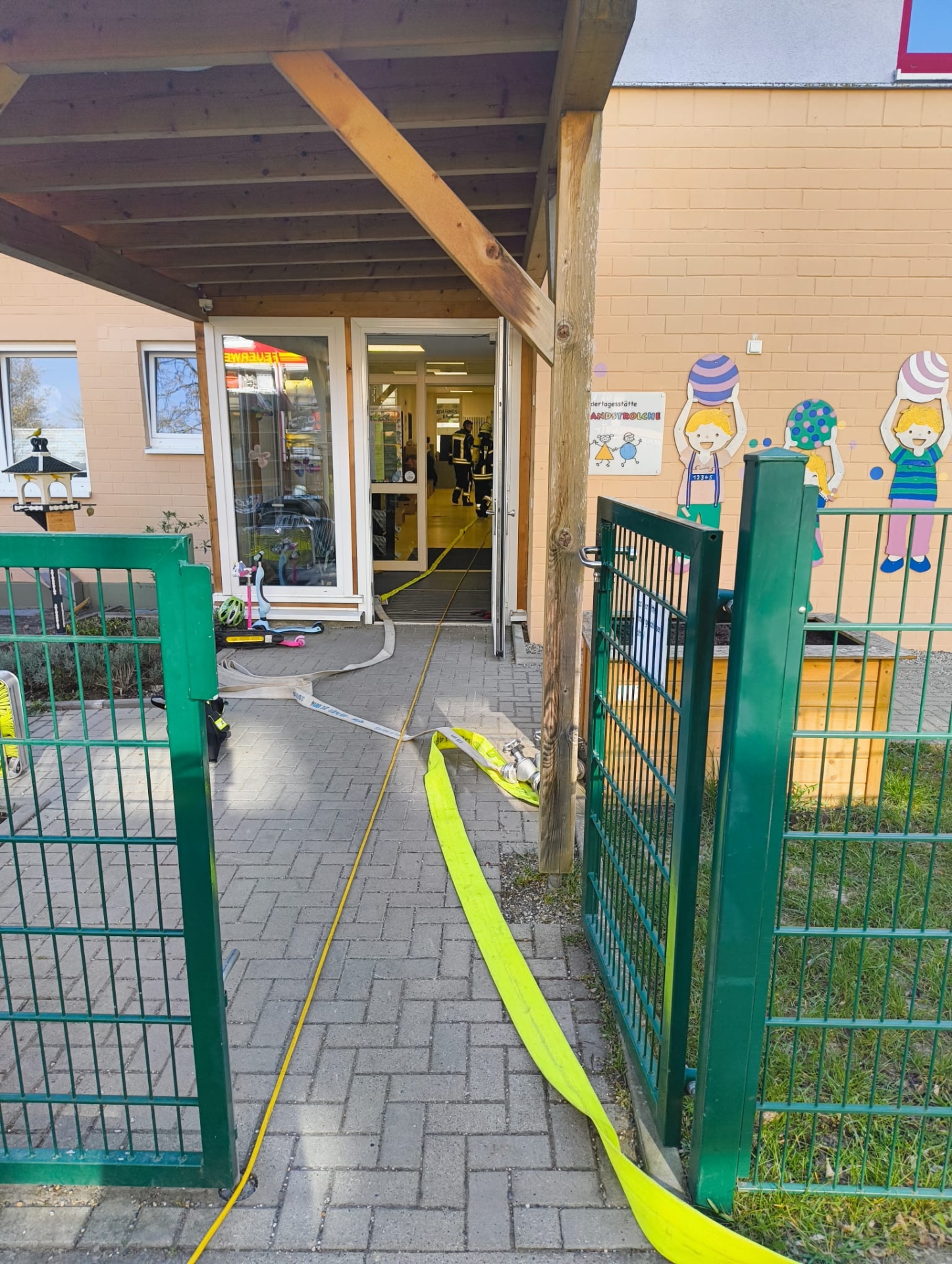 Feuerwehrübung in der Kindertagesstätte Hochlandstrolche Eingang der Kindertagesstätte Hochlandstrolche mit Feuerwehrschläuchen