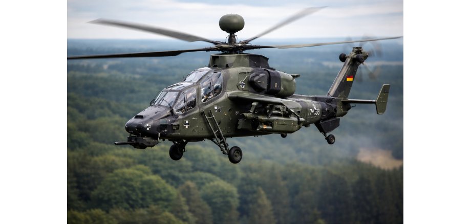 Auf dem Bild ist ein Kampfhubschrauber der Bundeswehr beim Flug zu sehen über einen Wald. 